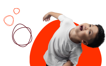 A boy in a white t-shirt looks upward with his mouth open, against a background with orange and red circles.