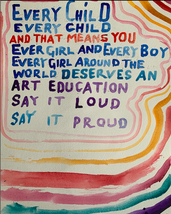 A colorful handwritten sign reads, "Every child and that means you, every girl and every boy, every girl around the world deserves an art education. Say it loud, say it proud.